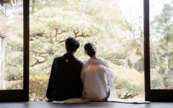 Doudantei｜和装姿のカップルが縁側に座り、庭園を見つめているイメージ