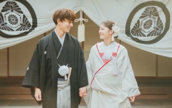 Futagawa Shuku Honjin｜和装姿のカップルが紋の入った幕を背景に撮影をしているイメージ