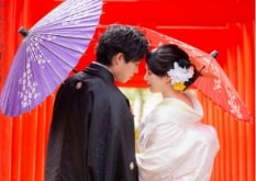 Yokiso｜和装姿のカップルが朱色の鳥居を背景に撮影をしているイメージ