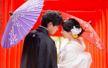 Yokiso｜和装姿のカップルが朱色の鳥居を背景に撮影をしているイメージ