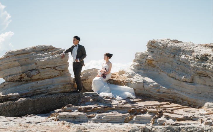 Noma Lighthouse｜洋装姿のカップルが岩礁を背景に撮影をしているイメージ