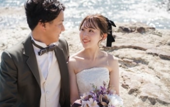 Noma Lighthouse｜洋装姿のカップルが岩礁を背景に撮影をしているイメージ