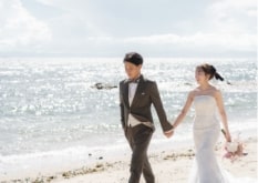 Noma Lighthouse｜洋装姿のカップルが砂浜を背景に撮影をしているイメージ