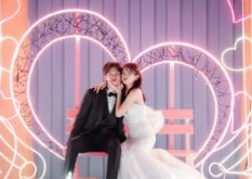 Nagoya Port Sea Train Land｜洋装姿のカップルが夜の遊園地のハートの撮影スポットで撮影をしているイメージ