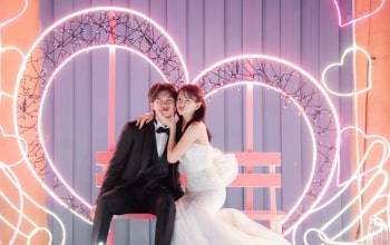Nagoya Port Sea Train Land｜洋装姿のカップルが夜の遊園地のハートの撮影スポットで撮影をしているイメージ