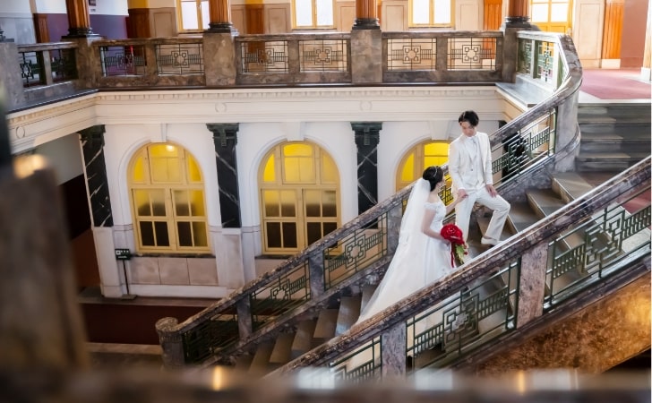 Nagoya City Archives and Museum｜洋装姿のカップルが重厚な階段で撮影をしているイメージ