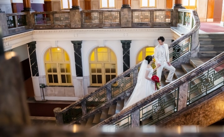 Nagoya City Archives and Museum｜洋装姿のカップルが重厚な階段で撮影をしているイメージ