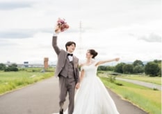 Shounai Ryokuchi Park｜洋装姿のカップルが河川敷の道で撮影をしているイメージ