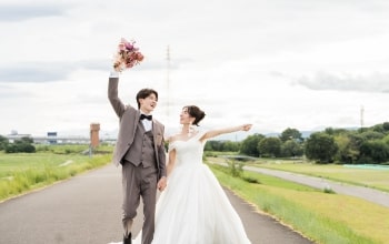 Shounai Ryokuchi Park｜洋装姿のカップルが河川敷の道で撮影をしているイメージ