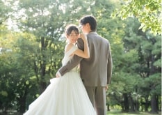 Shounai Ryokuchi Park｜洋装姿のカップルが木漏れ日の差す公園で撮影をしているイメージ